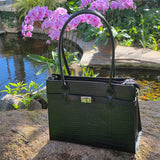 Black Italian leather full view handbag on a stone surface with pink flowers in the background - Don de Dieu Marque