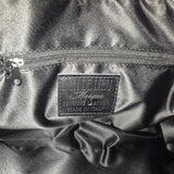 Close-up of a stitched label interior of leather handbag with 'Don de Dieu Marque Genuine Leather Made In Italy' branding.