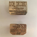 Two brass stamps engraved with our Brand logo on a light background what is used to hot stamp our logo collection bags. - Don de Dieu Marque 