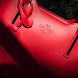 Close-up of a red Italian leather handbag with visible branding. - Don de Dieu Marque